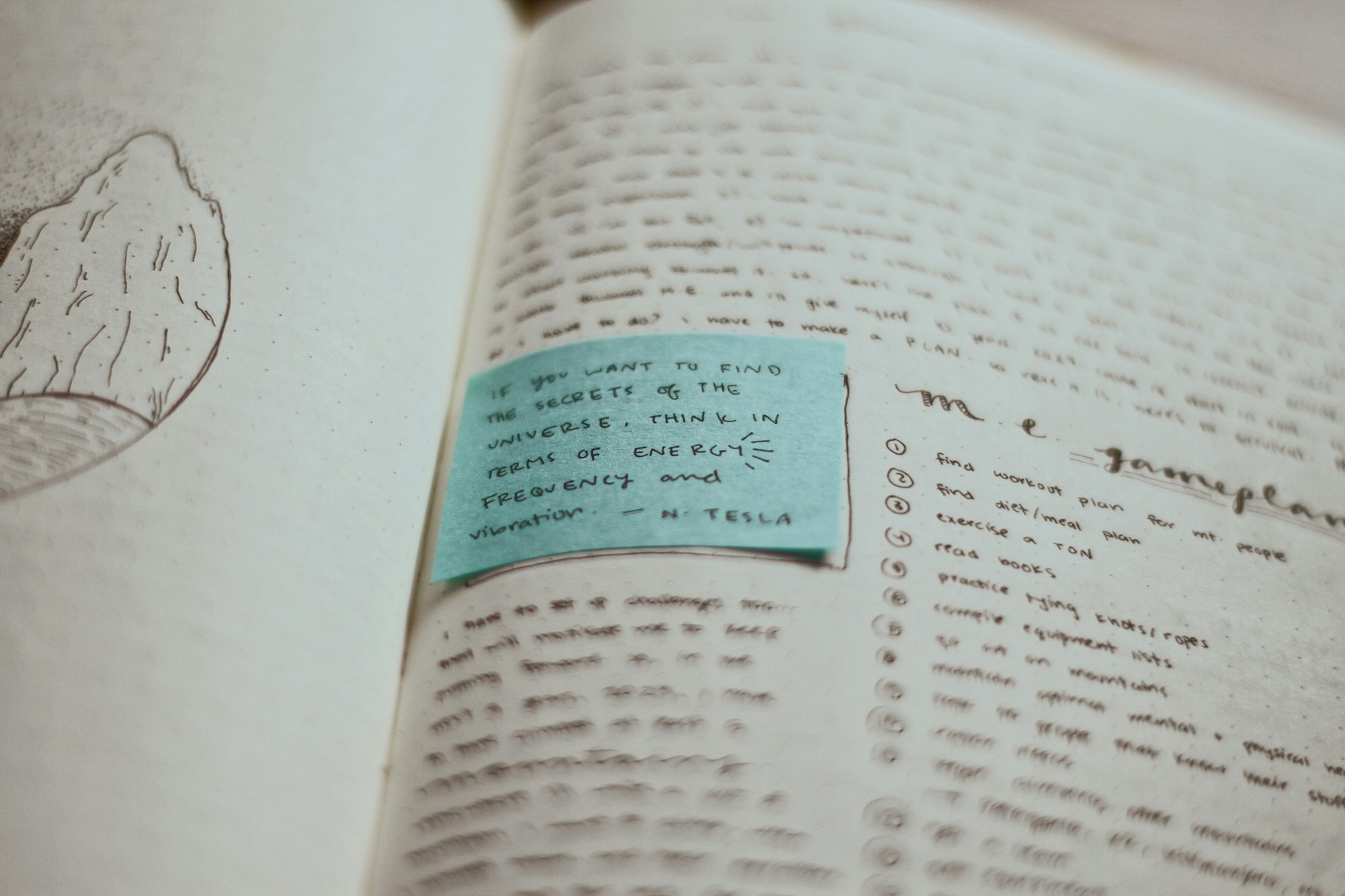A desk cluttered with printed papers, highlighters, and sticky notes