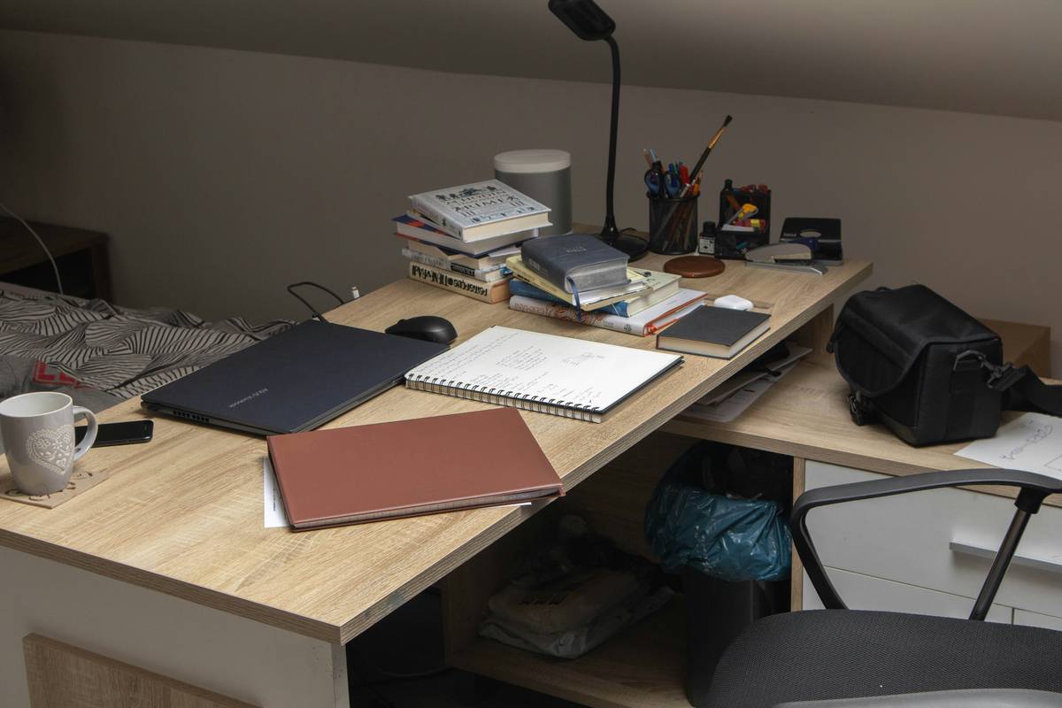 A cluttered desk filled with piles of disorganized paperwork.